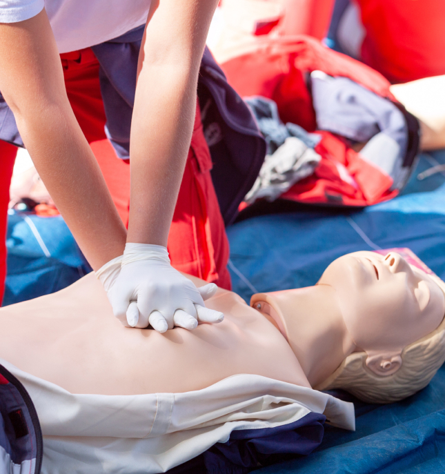 Person performing CPR eductation on a training dummy.