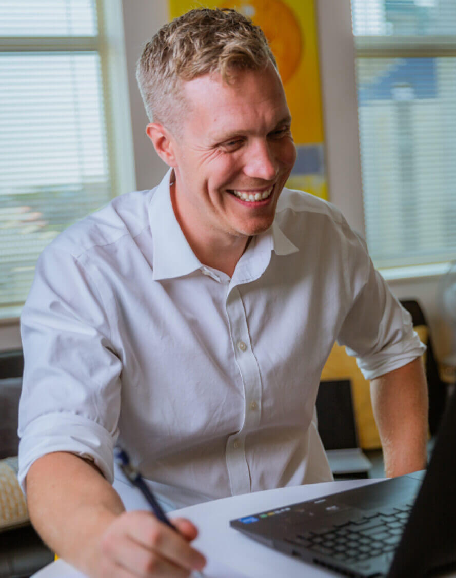 An independent financial advisor sitting in front of a laptop on a video call to a customer.